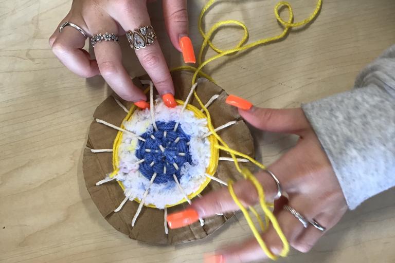 Two hands seen from above working on a craft project