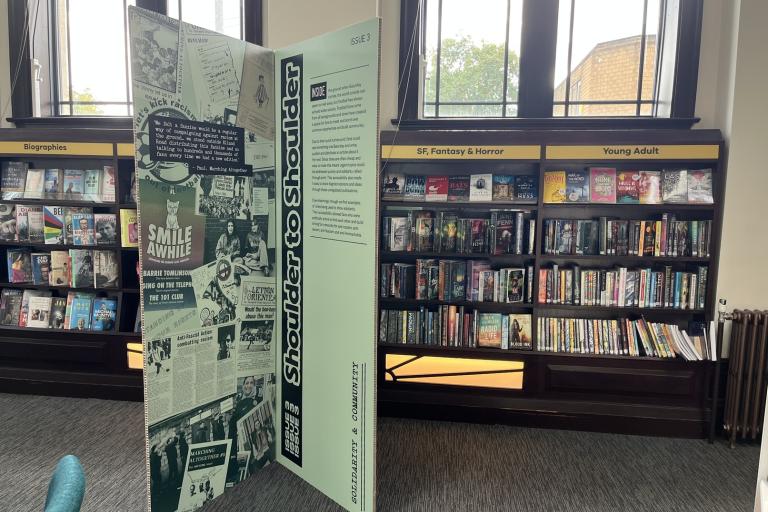 An internal photo of Hunslet Library with shelves of books and an exhibition panel